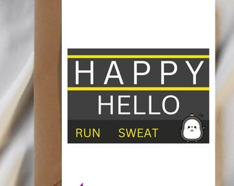 May include: A white greeting card with the words "HAPPY HELLO" in a black and yellow design. Below, the words "RUN SWEAT" are printed. A cartoon penguin is on the right. A brown envelope is behind the card.