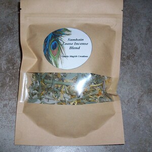 May include: A brown paper bag with a clear window, filled with a loose incense blend. The bag has a circular label with a peacock feather design and the text "Samhain Loose Incense Blend".