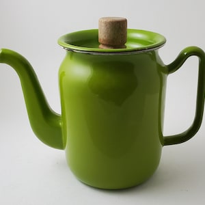 May include: A bright green enamel teapot with a wooden lid. The teapot has a spout and a handle.