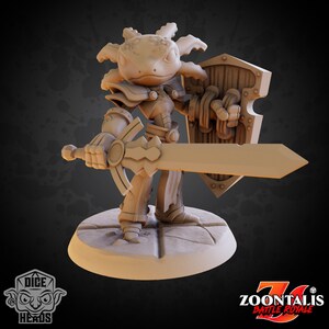 May include: A miniature figurine of a brown axolotl wearing armor and holding a sword and shield. The figurine is painted in a light brown color and is standing on a round base.