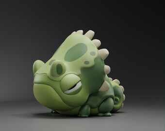 May include: A green and white cartoon chameleon figurine with a sleepy expression. The figurine has a textured surface and a spiky back.