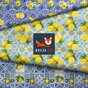 May include: A repeating pattern of yellow lemons with green leaves on a background of blue and white geometric tiles. A dark square logo in the center features a stylized orange fox and the text MODERN FOX in white and orange letters.