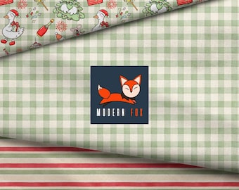 Puede incluir: Tela con una sección superior de patrón de cuadros vichy verde claro e ilustraciones festivas de gansos, regalos y calcetines. Un logotipo cuadrado central muestra un zorro naranja y el texto MODERN FOX sobre un fondo de cuadros verde claro.
