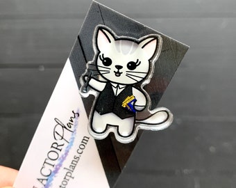 May include: A white cat with black eyes and a black vest is holding a microphone and a music note. The cat is standing on a black background with the text "ANACTOR Plans" and "anactorplans.com" in white.