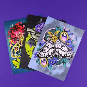May include: Three colorful illustrations of moths on a purple background. The moths are depicted with intricate details and vibrant colors, including purple, blue, green, yellow, and red. The illustrations are framed with a black border.
