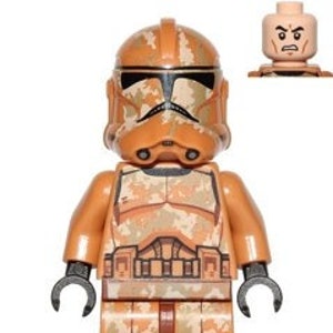 May include: A Lego minifigure of a clone trooper from the Star Wars universe. The figure is wearing tan and brown camouflage armour with a tan helmet. The figure has a black torso and legs.
