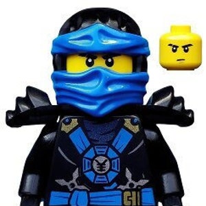 Może przedstawiać: Czarna minifigurka Lego z niebieską maską ninja i czarno-niebieskim strojem ninja. Minifigurka ma czarny pasek ze srebrną klamrą i srebrnym symbolem na klatce piersiowej. Minifigurka trzyma w każdej ręce srebrną broń.