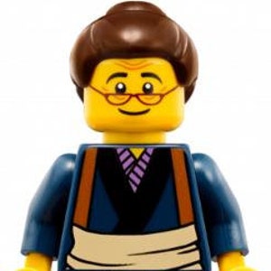 Könnte beinhalten: Eine Lego-Minifigur mit gelbem Kopf, braunen Haaren und Brille. Die Figur trägt ein blaues Oberteil mit einem schwarz-violett gemusterten Hemd, eine beige Hose und braune Schuhe. Die Figur hat gelbe Hände.