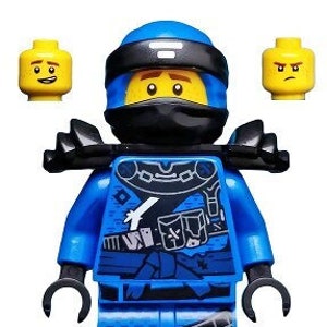 Może przedstawiać: Niebieska minifigurka Lego z czarną maską i niebiesko-czarnym strojem ninja. Minifigurka ma żółtą głowę z uśmiechającą się twarzą i czarnymi oczami.
