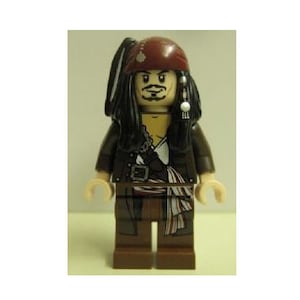 May include: A Lego minifigure of Captain Jack Sparrow from the Pirates of the Caribbean movie franchise. The figure is wearing a brown leather jacket, a red bandana, and a black wig. He has a sword and a pistol.