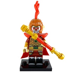May include: A LEGO minifigure of the Monkey King from the Journey to the West story. The figure is wearing a red and gold costume with a red cape and holding a golden staff. The figure has a red and white face with a fierce expression.