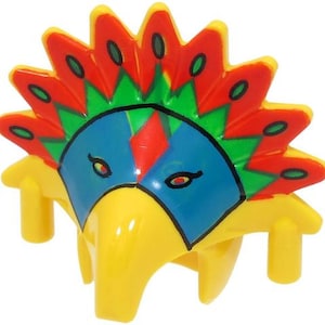 Könnte beinhalten: Ein gelber Spielzeug-Kopfschmuck mit einem farbenfrohen Design. Der Kopfschmuck hat ein blaues Gesicht mit roten und grünen Akzenten und eine rot-grüne Federkrone. Das Spielzeug hat eine schnabelartige Form und ist zum Tragen bestimmt.
