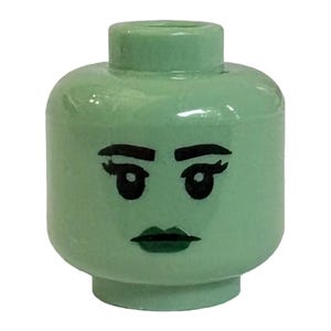 May include: A light mint green plastic toy figure head featuring a printed face with black eyebrows, eyelashes, and dark lips. The cylindrical head has a smooth, glossy finish and a small circular stud connector at the top for attachment.