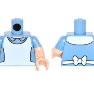 May include: Two Lego mini-figure torsos. One torso is light blue with a white apron and a black dot on the neck. The other torso is light blue with a white collar and a white bow on the back. Both have tan arms and hands.