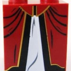 Op de afbeelding: Rode Lego-steen met een bedrukt ontwerp van een zwarte en gouden robe met een wit onderkleed.