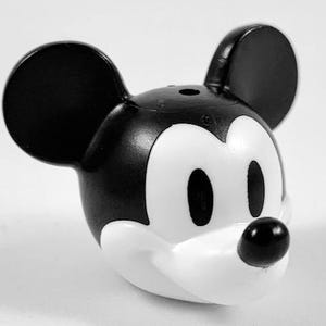 May include: A black and white Mickey Mouse figurine. The figurine features large, round black ears, a black nose, and a white face. The iconic character is a popular collectible item.