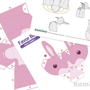 Puede incluir: Una plantilla de papel para imprimir para una caja de regalo de conejo de Pascua. La plantilla es rosa con detalles blancos y presenta una linda cara de conejo. La plantilla incluye instrucciones para doblar y ensamblar la caja.