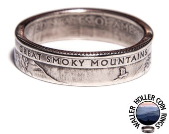 Könnte beinhalten: Ein silberner Ring aus einer Münze mit der Aufschrift "GREAT SMOKY MOUNTAINS" und dem Bild eines fliegenden Vogels. Der Ring trägt auch die Inschrift "UNITED STATES OF AMERICA". Der Ring ist ein einzigartiges Schmuckstück.
