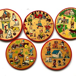 Può includere: Cinque puzzle vintage in legno con bordi rossi. I puzzle presentano illustrazioni colorate di animali da circo, gnomi, un'auto rossa e personaggi dei cartoni animati. La parola "SIMPLEX" è visibile su un puzzle.
