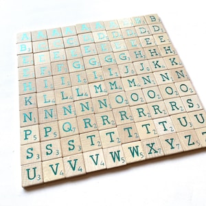 May include: A set of wooden letter tiles with a teal green glaze. The tiles are arranged in alphabetical order and include the letter values.