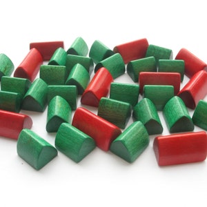 May include: A collection of wooden half-cylinder blocks in red and green. The blocks are arranged in a loose pile on a white surface.