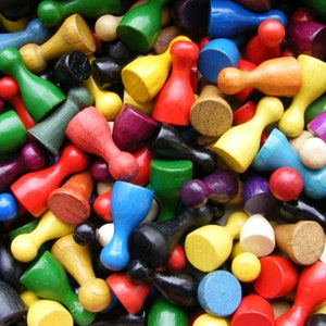 May include: A large collection of colorful wooden game pieces. The pieces are in various shapes and sizes, and they are all made of wood. The pieces are arranged in a random pattern, and they are all in focus.