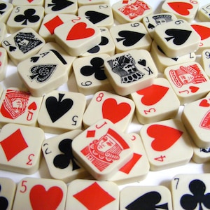 Pode incluir: Uma cole&ccedil;&atilde;o de azulejos quadrados brancos sujos com naipes e valores de cartas de jogar. Os azulejos exibem cora&ccedil;&otilde;es vermelhos, espadas pretas, paus e ouros, juntamente com figuras e n&uacute;meros. A disposi&ccedil;&atilde;o cria um padr&atilde;o visualmente envolvente.