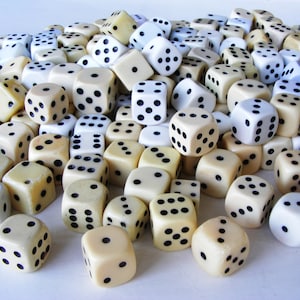 May include: A large pile of white and cream colored dice with black dots. The dice are scattered on a white surface.
