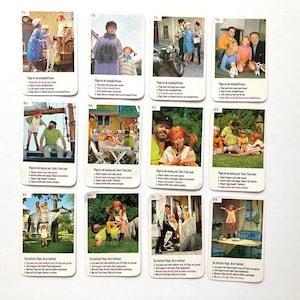 Op de afbeelding: Een verzameling vintage ruilkaarten met sc&egrave;nes uit een kinder-tv-programma. Elke kaart toont een kleurrijke afbeelding met tekst in een vreemde taal. De kaarten zijn rechthoekig met afgeronde hoeken.