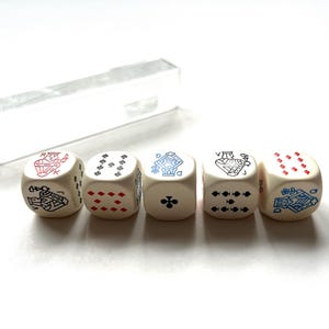 Può includere: Cinque dadi color avorio con simboli di carte da gioco in rosso e blu, tra cui un re, una regina e un fante. I dadi sono disposti in fila con una custodia di plastica trasparente sullo sfondo. Un set di gioco unico.