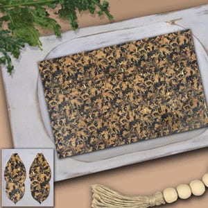 May include: A rectangular sheet of cork material with a repeating pattern of dark blue floral designs and gold accents. The image also shows a pair of teardrop-shaped earrings made from the same material, showcasing the pattern and color scheme.