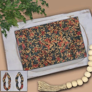 May include: Abstract patterned cork earrings and a matching rectangular piece. The earrings and rectangular piece feature a mix of red, navy, and gold accents on a tan background. The earrings are teardrop shaped.
