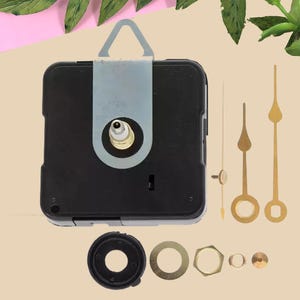 May include: A black square clock movement mechanism with a light gray hanger, three gold-colored clock hands of varying shapes, a black rubber washer, a gold-colored metal washer, a gold-colored hexagonal nut, and two small gold-colored fasteners.