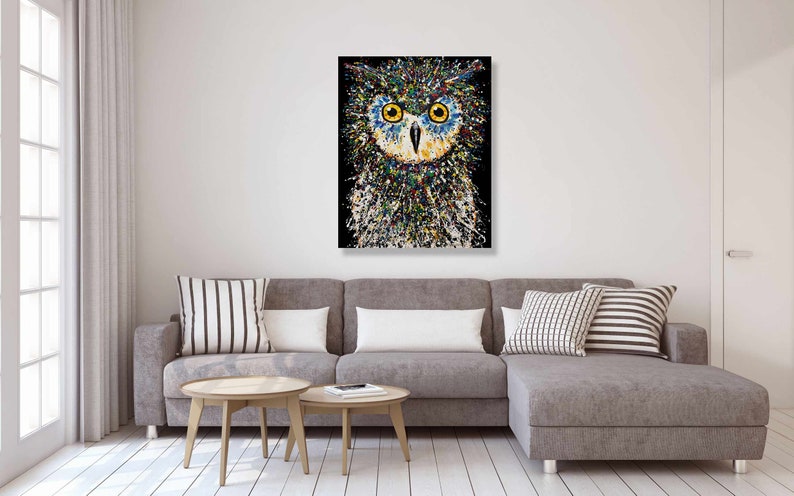May include: A colorful abstract painting of an owl with yellow eyes on a black background.