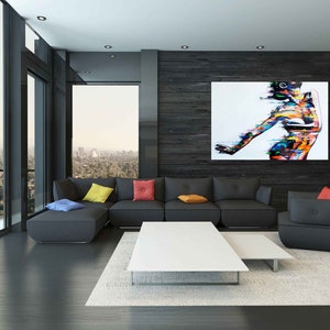 May include: A modern living room with a black sectional sofa, a white coffee table, and a large abstract painting of a person on a black wall.