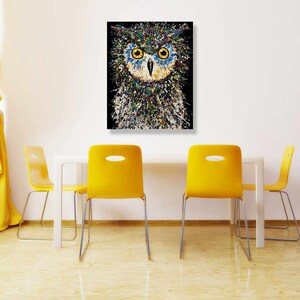 May include: A colorful abstract painting of an owl with blue eyes. The owl is painted in a splatter style with a black background.