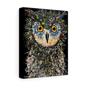 May include: A colorful abstract painting of an owl with yellow eyes. The owl is surrounded by a splatter of paint in various colors, including red, blue, green, and yellow. The background is black.