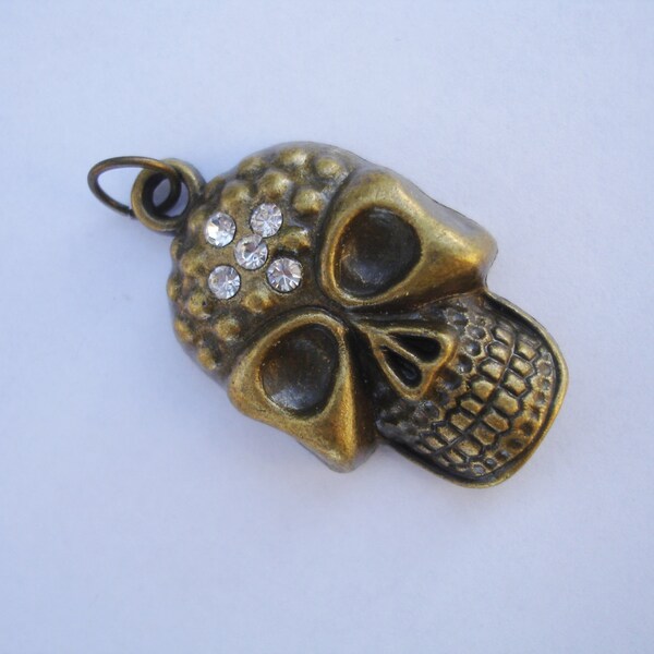 Antiqued gold skull with 4 crystals in the forehead one sided