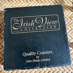 Pu&ograve; includere: Scatola nera con scritta dorata "The Irish View Collection" e "Quality Coasters by John Hinde Limited".