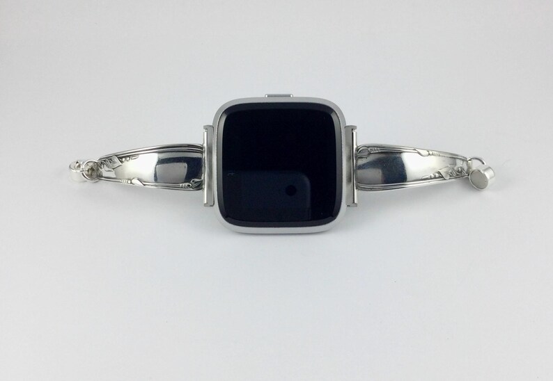 Peut inclure: Un bracelet de montre argent&eacute; fabriqu&eacute; &agrave; partir d'argenterie r&eacute;utilis&eacute;e. Le bracelet est con&ccedil;u pour s'adapter &agrave; une montre connect&eacute;e de forme carr&eacute;e. Le bracelet pr&eacute;sente un design d&eacute;coratif aux extr&eacute;mit&eacute;s.
