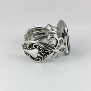 May include: Silver watch band made from a vintage silverware fork. The band is designed to fit a square-shaped smartwatch.