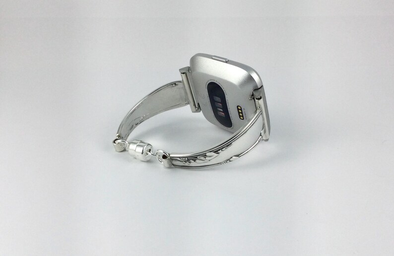 Peut inclure: Un bracelet de montre argent&eacute; avec un design d&eacute;coratif. Le bracelet est con&ccedil;u pour s'adapter &agrave; une montre intelligente de forme carr&eacute;e.