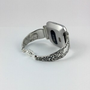 Puede incluir: Pulsera de reloj de plata con un dise&ntilde;o floral adornado. La pulsera est&aacute; hecha para adaptarse a un reloj inteligente de forma cuadrada.