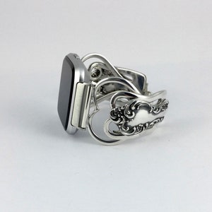 Puede incluir: Pulsera de reloj de plata hecha de cubiertos reutilizados con un dise&ntilde;o de coraz&oacute;n.
