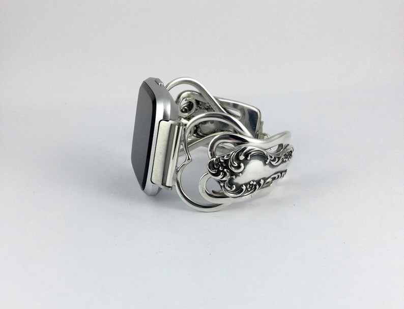 Puede incluir: Pulsera de reloj de plata hecha de cubiertos reutilizados con un dise&ntilde;o de coraz&oacute;n.