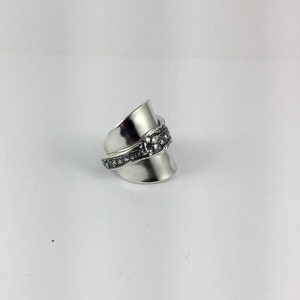 May include: A silver ring made from a repurposed spoon with a floral design.