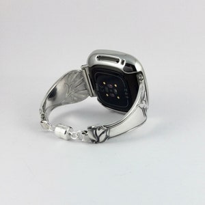 Peut inclure: Bracelet de montre en argent avec un motif floral. Le bracelet de montre est fait &agrave; partir d'une cuill&egrave;re r&eacute;utilis&eacute;e. Le cadran de la montre est noir et a une bordure argent&eacute;e.