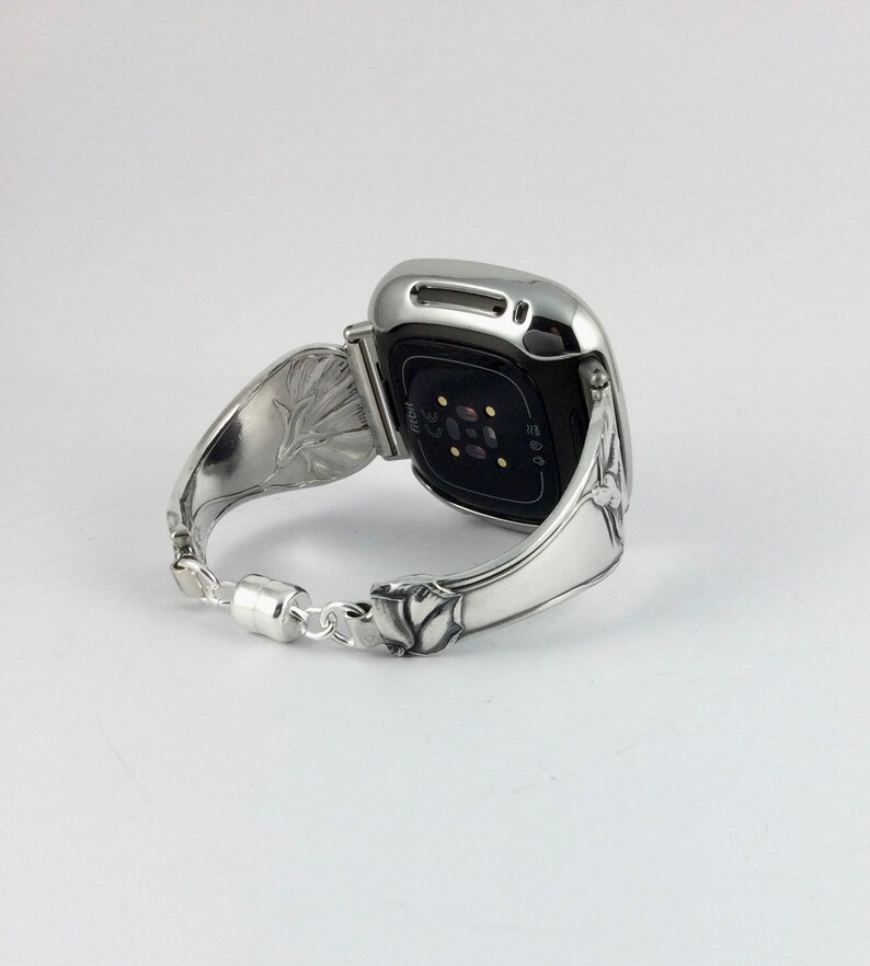 Peut inclure: Bracelet de montre en argent avec un motif floral. Le bracelet de montre est fait &agrave; partir d'une cuill&egrave;re r&eacute;utilis&eacute;e. Le cadran de la montre est noir et a une bordure argent&eacute;e.