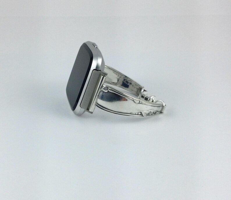 Peut inclure: Une montre connect&eacute;e argent&eacute;e avec un bracelet en m&eacute;tal argent&eacute;. Le bracelet est fait &agrave; partir d'une pi&egrave;ce de couverts r&eacute;utilis&eacute;e.