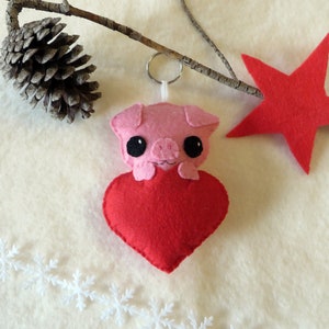 Peluche cochon rose dans un coeur rouge, en feutrine, à offrir pour Noël